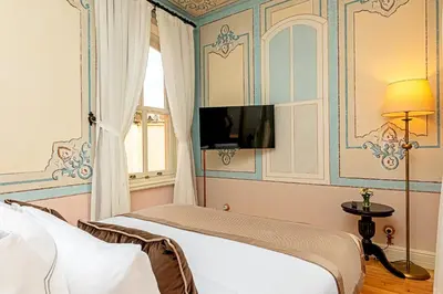 a bedroom with a bed and a tv on the wall at Meroddi Barnathan Hotel in Istanbul