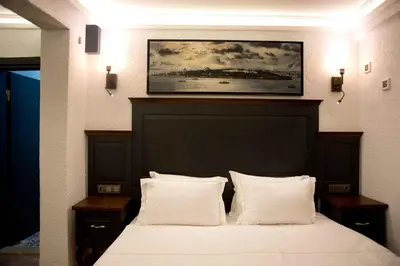 a bedroom with a bed with a painting on the wall at Big Orange Hotel Old City in Istanbul