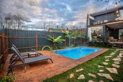 a backyard with a swimming pool and a chair on a deck at Sapanca Glamping in Sakarya
