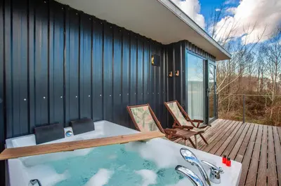 a bath tub sitting on a deck next to a house at Sapanca Glamping in Sakarya