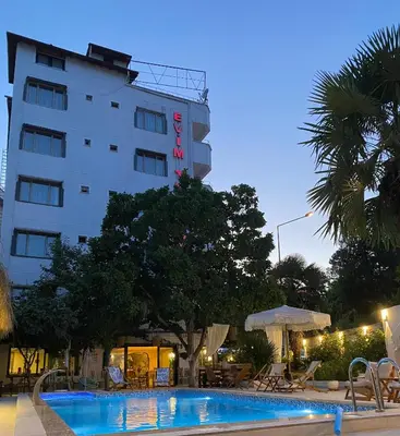 a hotel with a swimming pool in front of a building at EVİM APART HOTEL in Termal