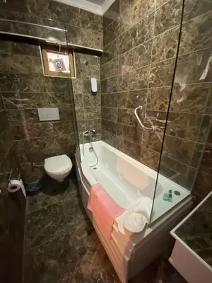 a bathroom with a bath tub and a toilet at EVİM APART HOTEL in Termal