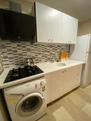 a kitchen with a washing machine and a sink at EVİM APART HOTEL in Termal