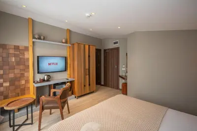 a bedroom with a bed and a desk and a television at Villa Siesta Hotel Istanbul Airport in Karaburun