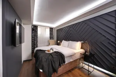 a bedroom with a large bed with a black wall at Xenia Hotel Istanbul in Istanbul