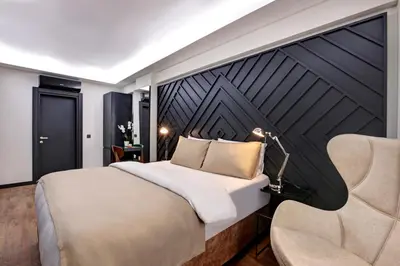 a bedroom with a large bed and a chair at Xenia Hotel Istanbul in Istanbul
