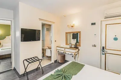 a bedroom with a bed and a bathroom with a sink at Hotel Fresia Istanbul in Istanbul