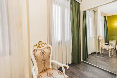 a white chair sitting in a room with a mirror at Hotel Fresia Istanbul in Istanbul