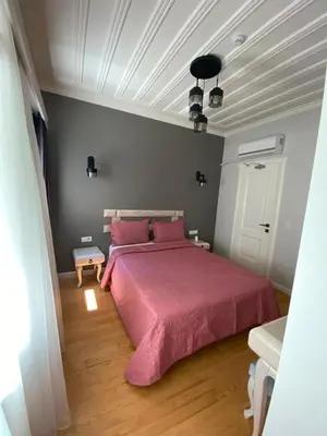 a bedroom with a large bed with pink sheets at White Island Boutique Otel in Adalar