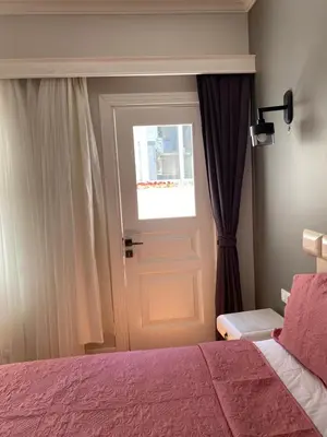 a bedroom with a door and a window and a bed at White Island Boutique Otel in Adalar