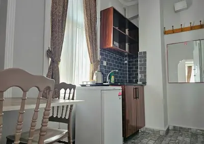 a small kitchen with a table and a small refrigerator at Grey House Apartments & Suites Istanbul in Istanbul