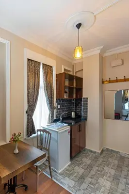 a kitchen with a table and a sink and a stove at Grey House Apartments & Suites Istanbul in Istanbul