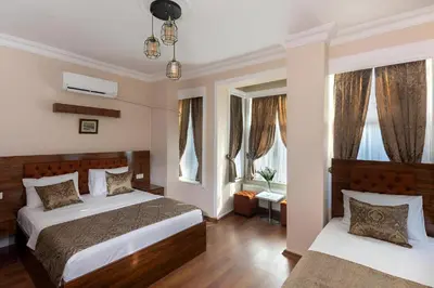 a bedroom with two beds and windows at Grey House Apartments & Suites Istanbul in Istanbul