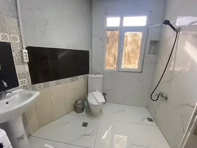 a white bathroom with a toilet and a sink at RAMO’S Aparatments & Suites in Istanbul