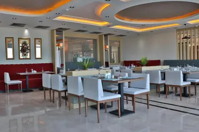 a dining room with tables and white chairs at The Sign Degirmen Hotel&Spa Wellness in Istanbul