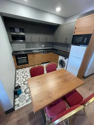 a kitchen with a wooden table and red chairs at Almin Apart Hotel in Istanbul