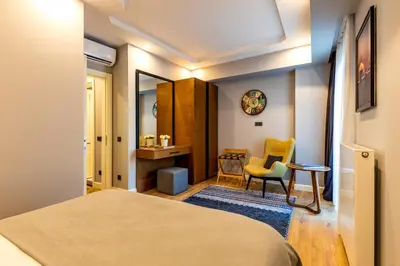 a bedroom with a bed and a desk and a chair at SALA SUITES in Istanbul