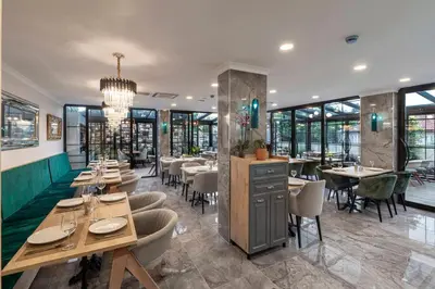 a dining room with tables and chairs and windows at LAGUN CASTLE HOTEL&SPA in Yalova