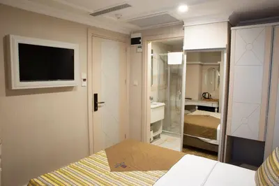 a bedroom with a bed and a tv on a wall at Alpinn Hotel DUE in Istanbul