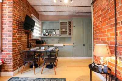a kitchen with a brick wall and a table and chairs at Galadoo Suites 3rd Floor in Istanbul