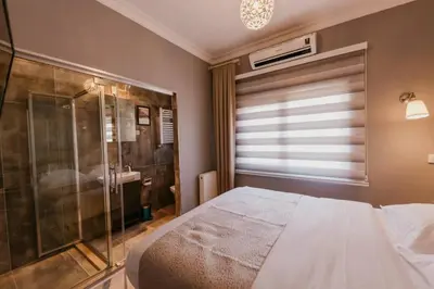 a bedroom with a bed and a glass shower at Galadoo Suites 4th Floor in Istanbul
