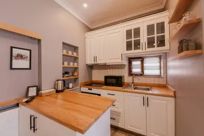 a kitchen with white cabinets and a wooden counter top at Galadoo Suites 4th Floor in Istanbul