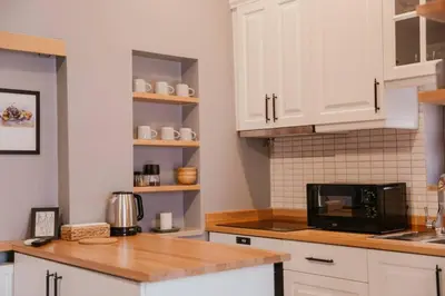 a kitchen with white cabinets and a black microwave at Galadoo Suites 4th Floor in Istanbul