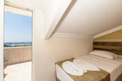 a white bedroom with a bed and a balcony at Bazaar Hotels Old City in Istanbul