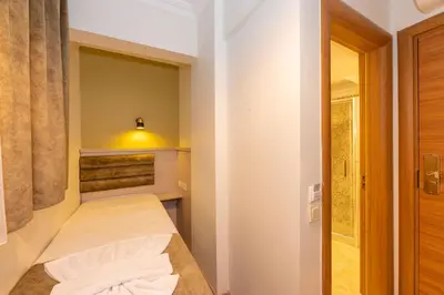 a small bedroom with a bed with a light above it at Bazaar Hotels Old City in Istanbul