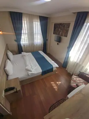 a bedroom with a large bed with blue curtains at Rumeli Konak Butik Otel in Tekirdag