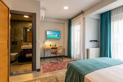 a hotel room with a bed and a bathroom at Green Parrot Hotel Istanbul in Istanbul
