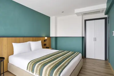 a bedroom with a white bed and a blue wall at Fragments Hotel in Istanbul