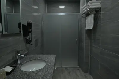 a bathroom with a sink and a shower with a phone at MİLLS HOTEL in Tekirdag