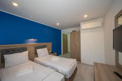 a bedroom with two beds and a blue wall at Okda Hotel in Istanbul