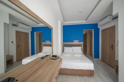 two beds in a room with a large mirror at Okda Hotel in Istanbul