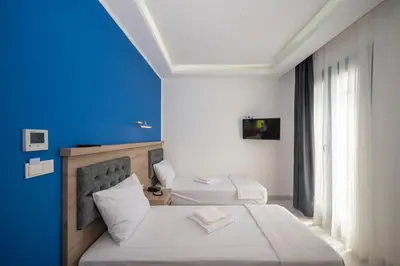 a bedroom with two beds and a blue wall at Okda Hotel in Istanbul