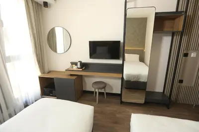 a hotel room with a mirror and a desk with a television at Moja City Hotel in Istanbul