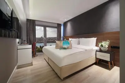 a bedroom with a large bed and a large window at Dora Pera Hotel in Istanbul