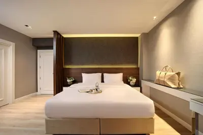 a bedroom with a large white bed with a sink at Dora Pera Hotel in Istanbul