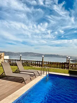 a swimming pool with two lounge chairs next to a swimming pool at Woodlodge Country Sapanca in Sapanca