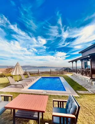 a backyard with a pool and a table and chairs at Woodlodge Country Sapanca in Sapanca