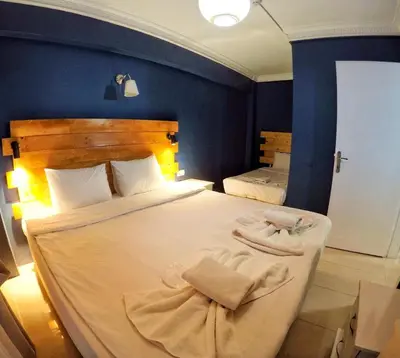 a bedroom with two beds with white sheets and blue walls at Laluna Hotel Near Grand Bazaar City Center in Istanbul