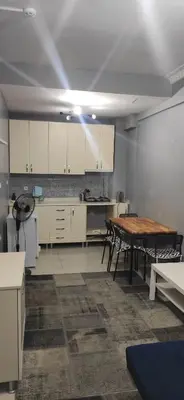 a kitchen with white cabinets and a wooden table at Laluna Hotel Near Grand Bazaar City Center in Istanbul