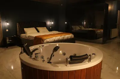 a bathroom with a bath tub and a bed at Mas Suites Karaköy in Istanbul