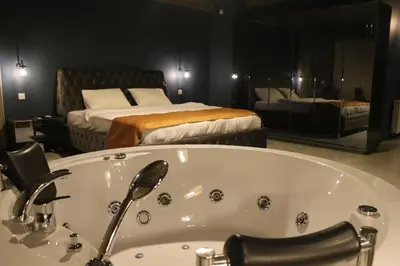 a bathroom with a tub and a bedroom with two beds at Mas Suites Karaköy in Istanbul