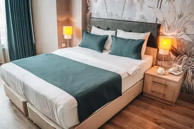 a bedroom with a large bed with blue pillows at La Flora House Hotel in Kocaeli