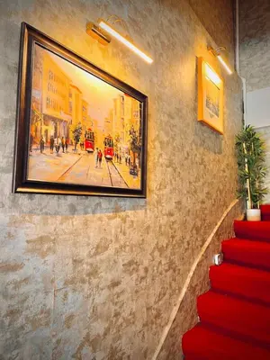a painting hanging on a wall with a red staircase at Rio Suite Hotel in Istanbul