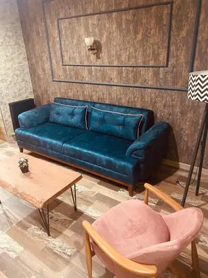 a blue couch in a room with a table and chairs at Rio Suite Hotel in Istanbul