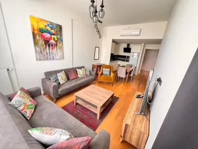 a living room with a couch and a table at G Tower Residence at Divan Near To Mimar Sinan Metro Station in Istanbul