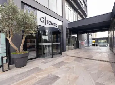 a building with a tree in front of a store at G Tower Residence at Divan Near To Mimar Sinan Metro Station in Istanbul